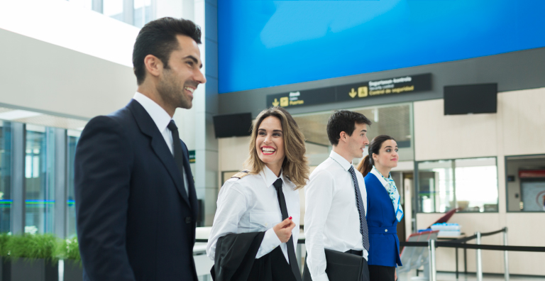 4名机场工作人员微笑着站成一排。